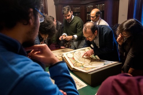 Professor and students examining a map.